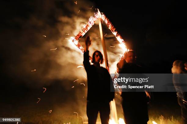 Members of the National Socialist Movement, one of the largest neo-Nazi groups in the US, hold a swastika burning after a rally on April 21, 2018 in...