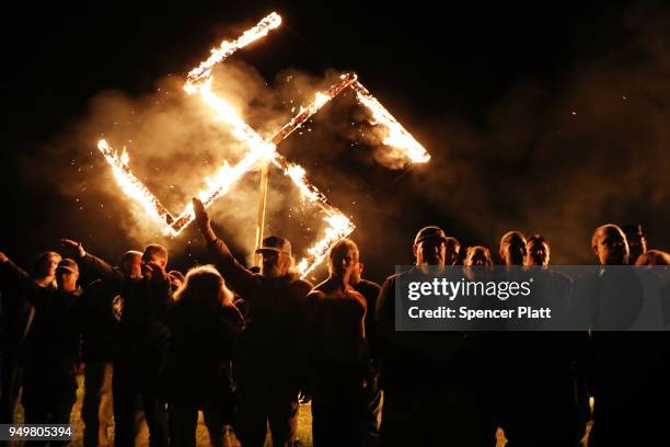 Members of the National Socialist Movement, one of the largest neo-Nazi groups in the US, hold a swastika burning after a rally on April 21, 2018 in...