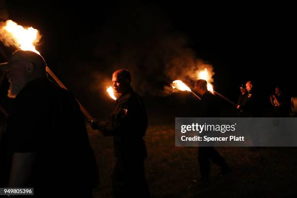 Members of the National Socialist Movement, one of the largest neo-Nazi groups in the US, hold a swastika burning after a rally on April 21, 2018 in...