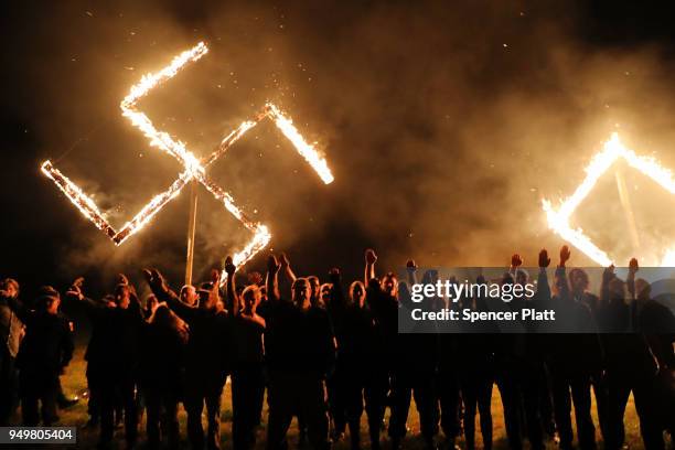 Members of the National Socialist Movement, one of the largest neo-Nazi groups in the US, hold a swastika burning after a rally on April 21, 2018 in...