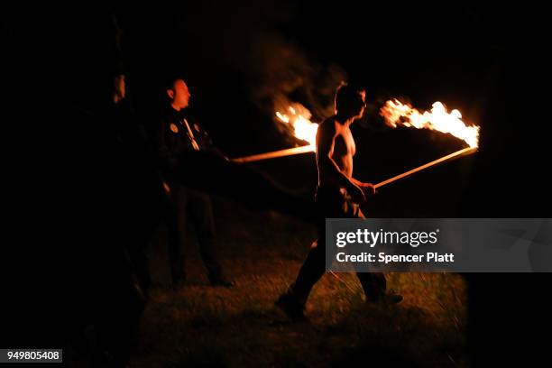 Members of the National Socialist Movement, one of the largest neo-Nazi groups in the US, hold a swastika burning after a rally on April 21, 2018 in...