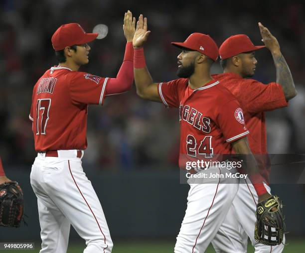 Starting pitcher Shohei Ohtani of the Los Angeles Angels of Anaheim high fives center fielder Chris Young after they defeated San Francisco Giants at...