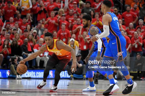 Donovan Mitchell of the Utah Jazz dribbles around Paul George and Russell Westbrook of the Oklahoma City Thunder in the second half during Game Three...