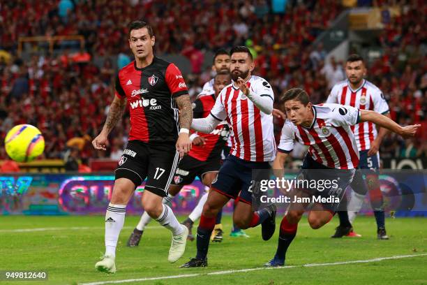 Milton Caraglio of Atlas and Juan Basulto of Chivas compete for the ball during the 16th round match between Atlas and Chivas as part of the Torneo...