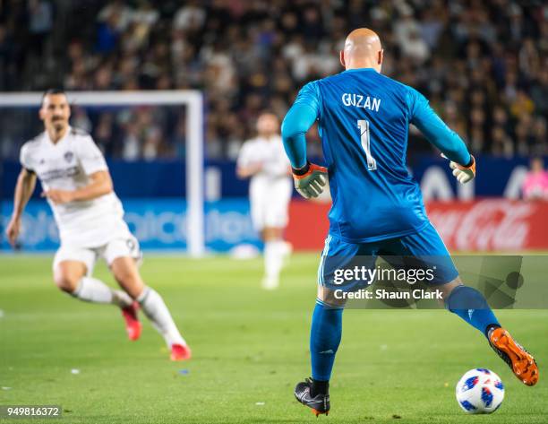 Brad Guzan of Atlanta United passes the ball as Zlatan Ibrahimovic of Los Angeles Galaxyc charges in during the Los Angeles Galaxy's MLS match...