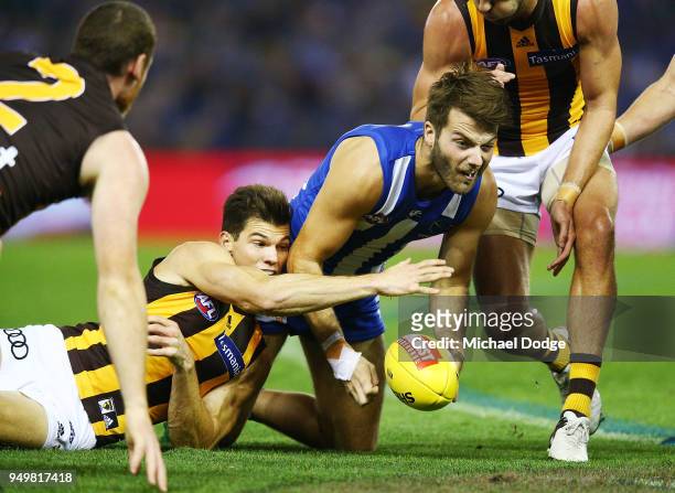 Luke McDonald of the Kangaroos handballs from Jaeger O'Meara of the Hawks during the round five AFL match between the North Melbourne Kangaroos and...