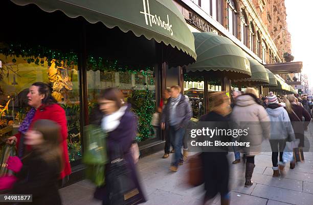 Shoppers pass Harrods department store in Knightsbridge, London, U.K., on Saturday, Dec.19, 2009. Shoppers hit the high street in force over the...