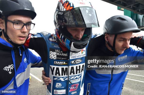 Spanish David Checa is escorted by his mechanics following his crash on his Yamaha GMT Formula EWC N°94, losing the first place after 470 laps in the...
