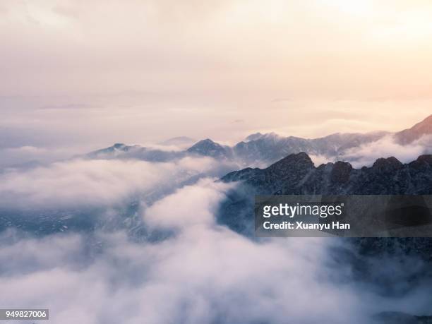 clouds drift amid rocky cliffs. - misty mountains stock-fotos und bilder