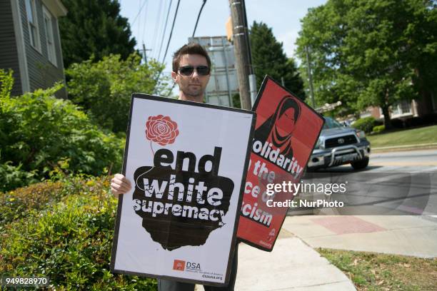 Protester displays his signs during a National Socialist Movement rally at Greenville Street Park in Newnan, Georgia, USA on April 21, 2018.