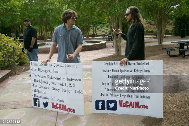 Two men hold anti-Semitic signs during a National Socialist Movement rally at Greenville Street Park in Newnan, Georgia, USA on April 21, 2018.
