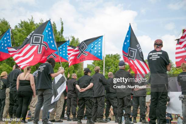 Neo-Nazis hold flags during a National Socialist Movement rally at Greenville Street Park in Newnan, Georgia, USA on April 21, 2018.