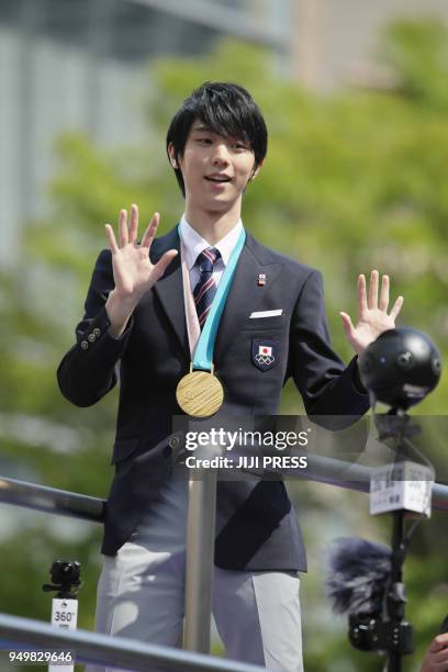 Two-time Olympic figure skating men's singles gold medallist Yuzuru Hanyu waves during his victory parade in his home town of Sendai city on April...