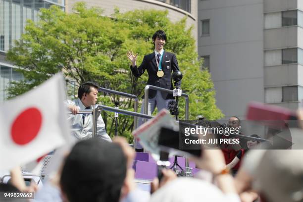 Two-time Olympic figure skating men's singles gold medallist Yuzuru Hanyu waves during his victory parade in his home town of Sendai city on April...