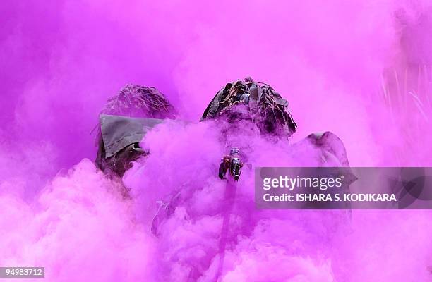 Sri Lankan Air Force troops walk through coloured smoke as they display their commando skills during a passing out ceremony of 329 men and officers...