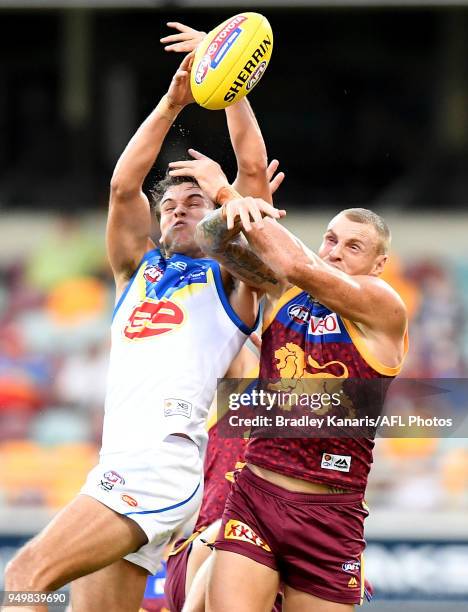 Jack Bowes of the Suns and Mitch Robinson of the Lions challenge for the ball during the round five AFL match between the Brisbane Lions and the Gold...