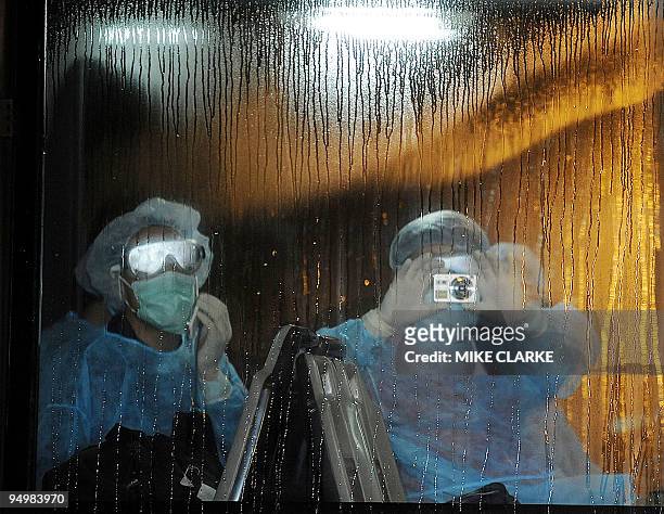 Two Mexicans wait on a bus prior to boarding a plane sent by Mexico in Hong Kong on May 6, 2009. Hong Kong's only confirmed case of swine flu will...