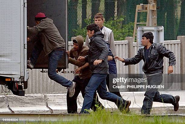 Afghan border escorts help illegal migrants to get into a truck on May 14, 2009 in Calais, northern France. Thousands of migrants pass through Calais...