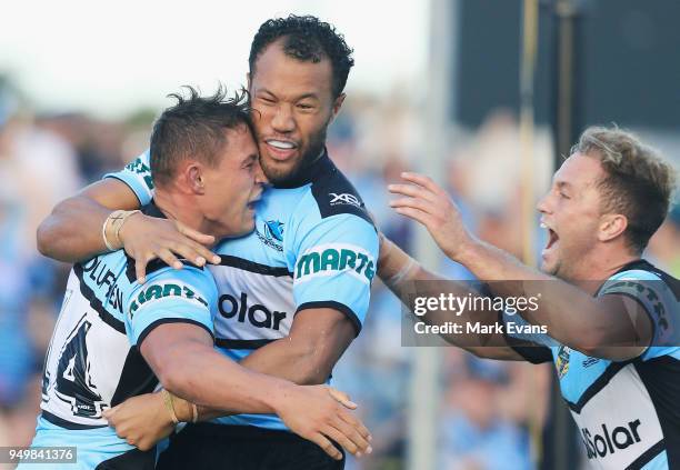 Scott Sorensen of the Sharks celebrates a try with Joseph Paulo and Matt Moylan during the round seven NRL match between the Cronulla Sharks and the...