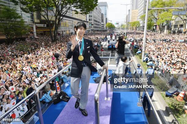 Two-time Olympic figure skating men's singles gold medallist Yuzuru Hanyu waves during his victory parade in his home town of Sendai city on April...