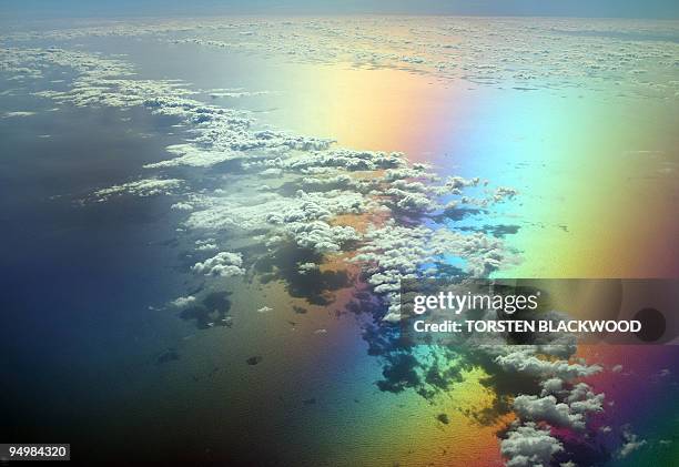 Scattered clouds over Bass Strait take on a surreal appearance when viewed from a tinted aircraft window through a circular polariser, 11 January...