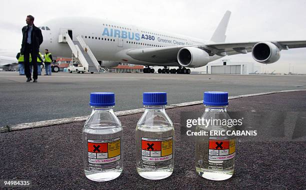 One bottle containing kerozene and two bottles containning GTL, "green" liquid fuel made from natural gas, are pictured on the tarmac in front of the...