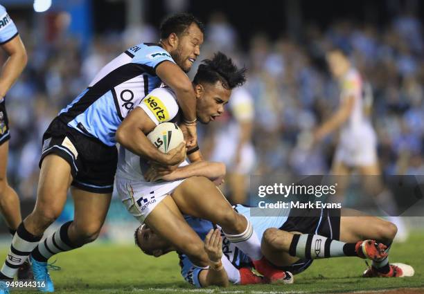 Christian Crichton of the Panthers is tackled by Joseph Paulo of the Sharks during the round seven NRL match between the Cronulla Sharks and the...