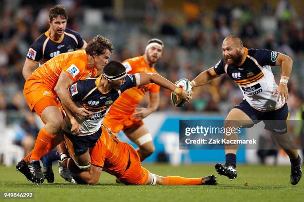 Darcy Swain of the Brumbies passes to Robbie Abel of the Brumbies as he is tackled by Marcos Kremer of the Jaguares during the round 10 Super Rugby...