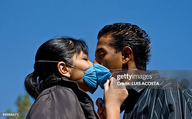 Couple kisses as they make a line to be assisted at an Influenza A prevention and detection medical mobile unit in Mexico City, on April 29, 2009....