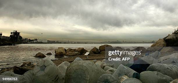 Smog covers the skyline of Beirut while empty plastic bottles and trash pollute the shore of the Mediterranean off Dbayeh, as suburb of the Lebanese...