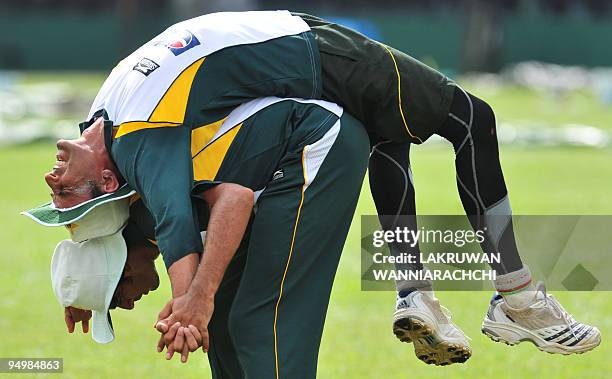 Pakistani cricketer Abdur Rauf and cricket captain Younus Khan stretch during a practice session at the P. Saravanamuttu Stadium in Colombo on July...