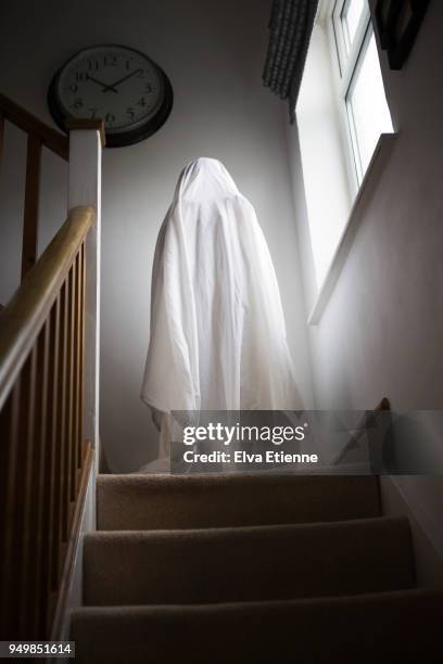 spooky child standing on stairs in ghost costume - chair de poule photos et images de collection