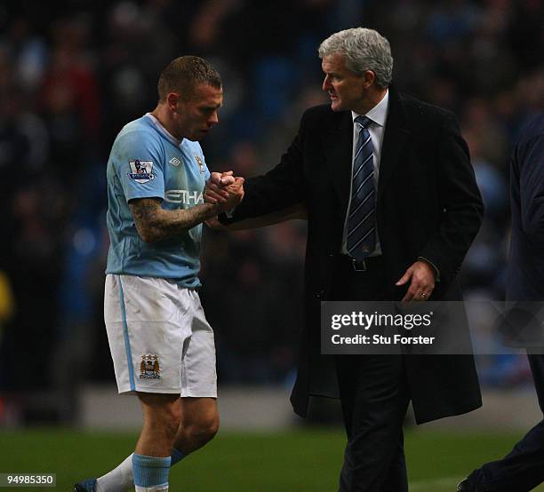 Manchester City manager Mark Hughes congratulates Craig Bellamy as he is substituted during the Barclays Premier League game between Manchester City...