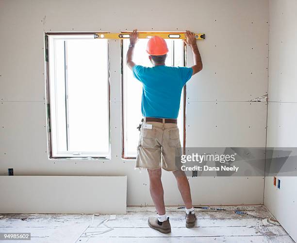construction worker holding level - dana workman stockfoto's en -beelden