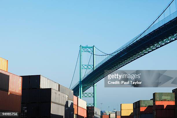 shipping containers with bridge - port of los angeles stock-fotos und bilder