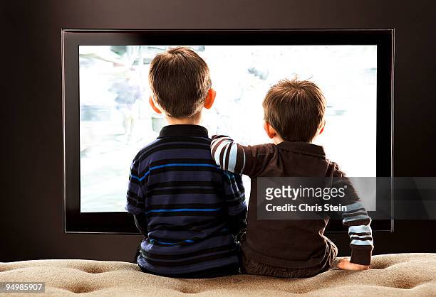 brothers watching tv - arm in arm stockfoto's en -beelden