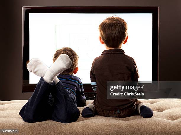 brother's watching tv - boy at television stockfoto's en -beelden