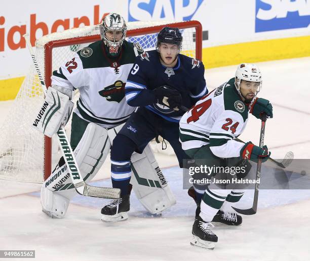 Andrew Copp of the Winnipeg Jets fights for space with Matt Dumba and Alex Stalock of the Minnesota Wild in Game Five of the Western Conference First...