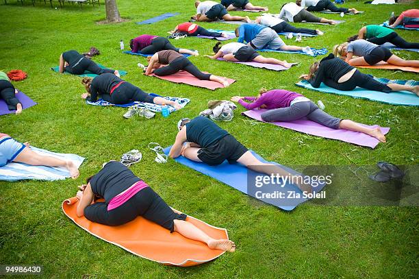 group yoga session in public park - yoga outdoor foto e immagini stock