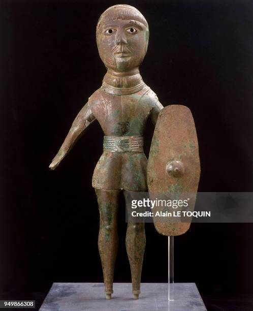 Dieu guerrier gaulois en bronze aux yeux incrustés muni d'un torque , d'un bouclier, d'une ceinture et d'une tunique, découvert sur le site de St...