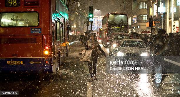 Snow falls on Oxford Street in central London, as shoppers continue their last-minute Christmas shopping, on December 21, 2009. The death toll from...