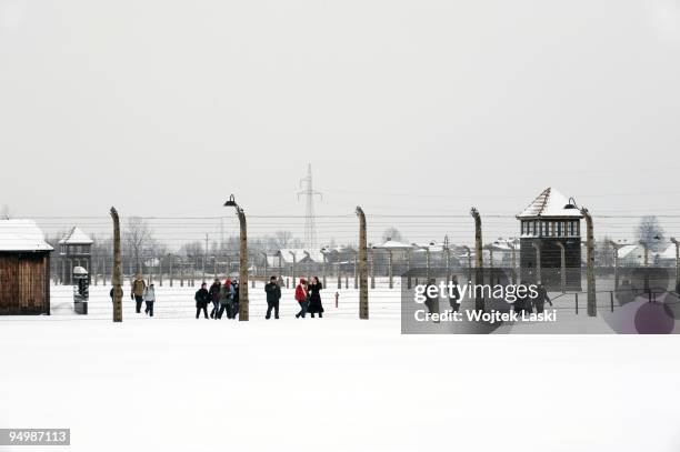 Visitors to Auschwitz Concentration Camp walk along the life barbed wire at Auschwitz II-Birkenau extermination camp on December 17, 2009 in...