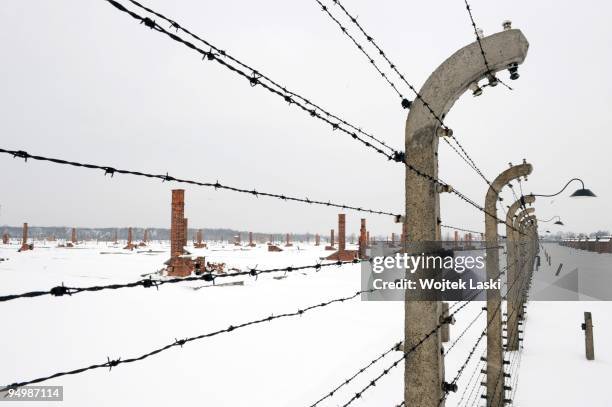 The wrecked chimneys of the former Auschwitz II-Birkenau extermination camp seen through a life barbed wire on December 17, 2009 in Brzezinka,...