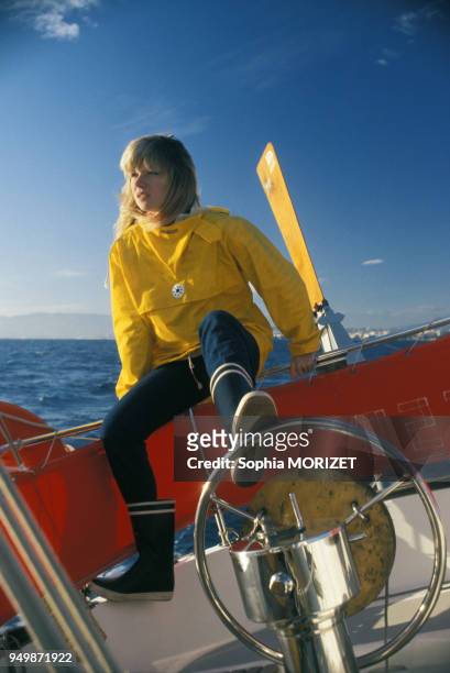 La chanteuse Karen Cheryl en ciré jaune sur un voilier en août 1977.