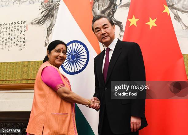 Indian Foreign Minister Sushma Swaraj shakes hands with Chinese Forein Minister Wang Yi have a meeting at the Diaoyutai State Guest House on April...
