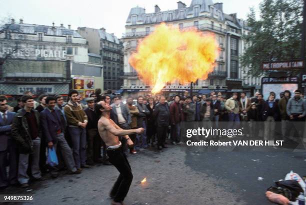 Cracheur de feu, en novembre 1980, place Pigalle à Paris, France.