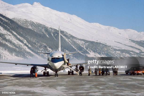 Passagers descendant d'un avion de tourisme dans une station de ski, circa 1980.