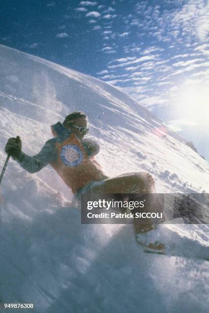 Un skieur chute sur la neige, circa 1980.