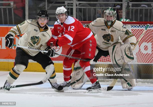 James Livingston of the Sault Ste. Marie Greyhounds battles between Scott Harrington and Michael Hutchinson of the London Knights in a game on...
