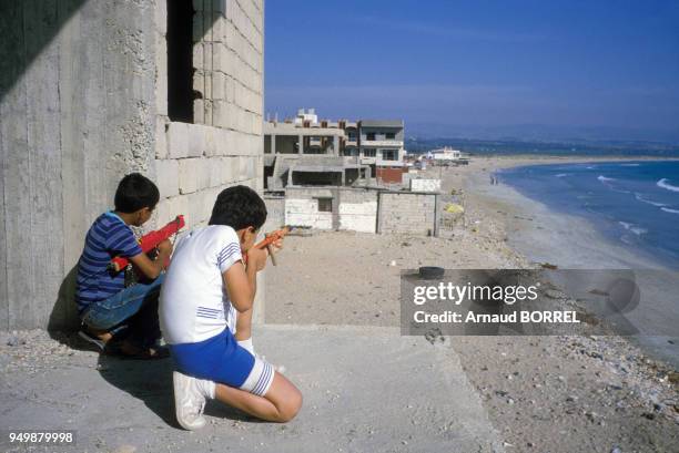 Enfants jouant à la guerre en mai 1985 sur le bord de mer au Liban.